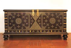 an ornate wooden chest sitting on top of a hard wood floor