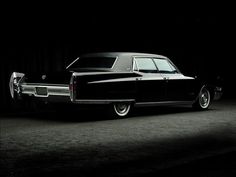 an old black car is parked in the dark