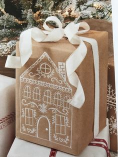 a gift wrapped in brown paper with a gingerbread house on it