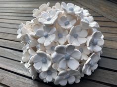 a white flower arrangement sitting on top of a wooden table