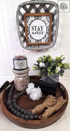 a tray that has some flowers and candles in it on top of a wooden table