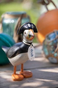 a toy duck with a pirate hat and tag on it's head sitting on the ground