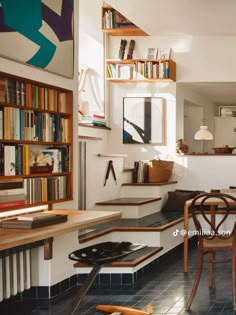 a room with many bookshelves and tables in it