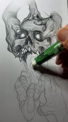 someone is drawing a skull with a green marker