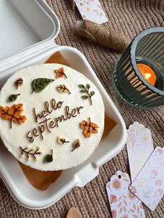 a cake that is sitting in a container on the ground next to some paper tags