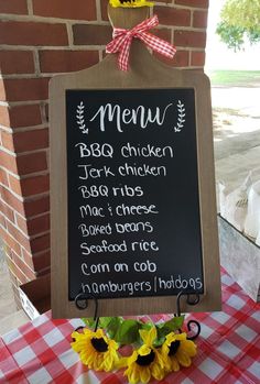 a blackboard sign sitting on top of a red and white checkered table cloth