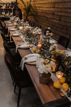 a long table with candles and flowers on it is set up for a formal dinner