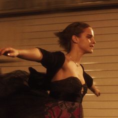 a woman in a black dress is dancing