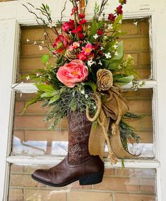 a boot with flowers in it hanging from a window sill