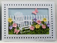 a card with flowers and a white picket fence