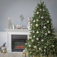 a decorated christmas tree in front of a fireplace