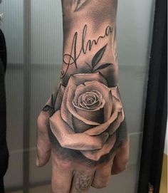 a woman's hand with a rose tattooed on it and the word ann written in cursive writing