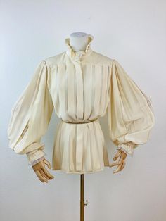 Vintage 1980s Pleated Silk Blouse pleats at front hidden buttons at front big balloon sleeves with lace  buttons at cuff with lace trim vanilla in color 100% silk material Great vintage condition appx size -  S / M 20 pit-pit 26.5 length 26 sleeve All sales are final Vintage Puff Sleeve Blouse With Gathered Sleeves, Vintage Bishop Sleeve Formal Blouse, Vintage Bishop Sleeve Blouse For Formal Occasions, Vintage Beige Puff Sleeve Blouse, Cream Blouse With Puff Blouson Sleeves, Cream Blouse With Blouson Puff Sleeves, Vintage Cream Puff Sleeve Tops, Cream Puff Sleeve Blouse For Daywear, Cream Blouse With Blouson Bishop Sleeves