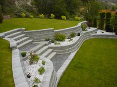 an aerial view of a garden with steps leading up to the grass and bushes on either side