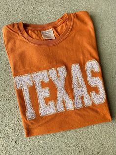 These TEXAS shirts are super trendy as well as the perfect touch to wear on game day! Shirts are Comfort Wash brand and the shirt color is Texas Orange! Shirts are unisex and available in short and long sleeve and sweatshirts! ❗️Sizes: Adult S-3XL The tee has a white TEXAS stitched onto the t shirt in real white sequin fabric! If you would like to request a custom order, please send us a message!! Texas Shirt, Texas Shirts, Orange Texas, Sequin Appliques, Long Sleeve Sequin, Game Day Shirts, Sequin Fabric, Shirt Color, Long Sweatshirt