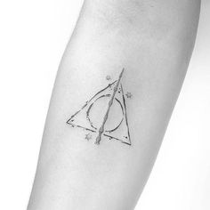 a harry potter symbol tattoo on the left inner forearm and arm, with stars around it