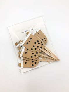 six wooden pegs with black dots on them sitting in a bag next to each other