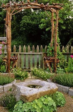 an outdoor garden with lots of plants and flowers on the ground, surrounded by wooden arbors