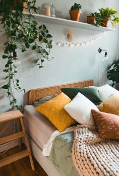 a bed topped with lots of pillows and plants