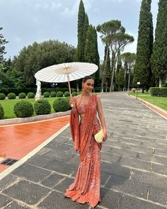 a woman is holding an umbrella and posing for the camera