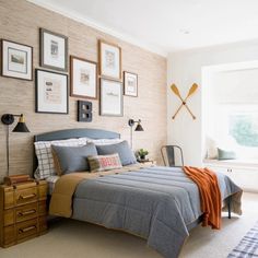 a bed sitting in a bedroom next to a window with pictures on the wall above it