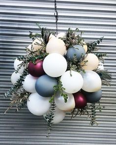 a bunch of balloons that are hanging from a ceiling fixture in front of a metal wall