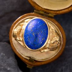 This mens statement ring showcases an oval lapis cabochon with plenty of pyrite flecks. The lapis is bezel-set into a ring with hissing cobra details on each shoulder. The ring is crafted in 14k yellow gold and is currently a size 8.75. Luxury Lapis Lazuli Oval Rings, Luxury Oval Lapis Lazuli Rings, Formal Lapis Lazuli Oval Rings, Oval Lapis Lazuli Rings For Formal Occasions, Luxury Oval Lapis Lazuli Jewelry, Serpent Ring, The Ring, Bezel Setting, Statement Ring