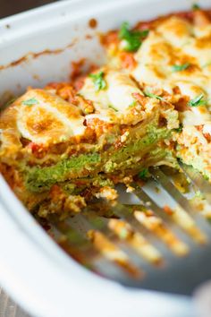 a close up of a fork in a casserole dish with broccoli and cheese