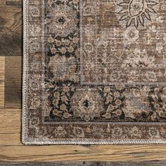 a brown and black area rug on top of a wooden floor