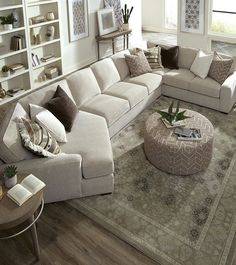 a living room filled with furniture on top of a hard wood floor covered in lots of pillows