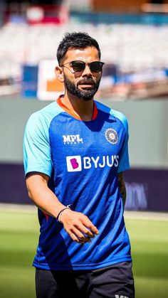 a man in blue shirt and sunglasses on field