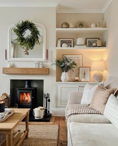 a living room filled with furniture and a fire place in the middle of it's wall