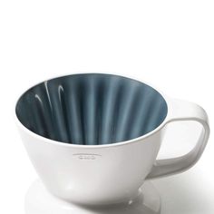 a white coffee cup with blue stripes on the rim and saucer is shown in front of a white background