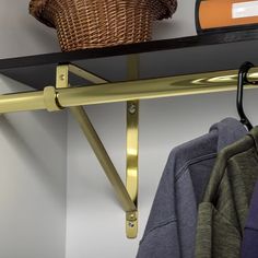 a shelf that has some clothes on it and a basket hanging from the wall behind it