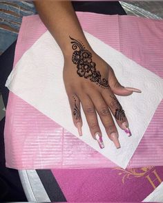 a woman's hand with hendix on it sitting on top of a towel