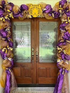 the front door is decorated with purple and gold ribbons, tiger head on it's side