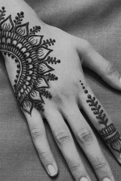 a woman's hand with henna tattoos on it