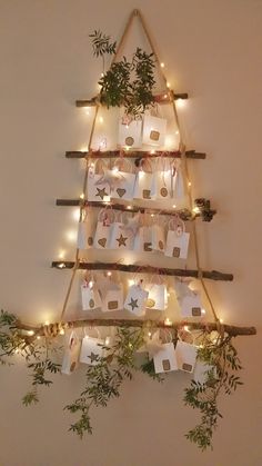 a christmas tree made out of branches and wrapped presents with lights on the top is decorated with string lights