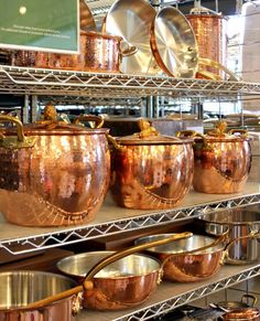 copper pots and pans on shelves in a kitchen