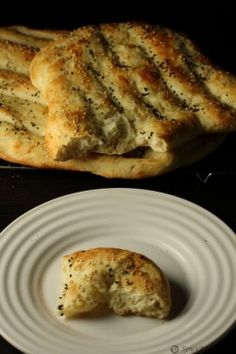 two pieces of bread sitting on top of a white plate next to another piece of bread