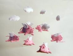 a group of pink pigs flying through the air with clouds in the sky above them