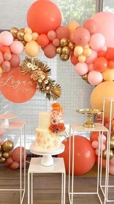 a table topped with cake and balloons in front of a window