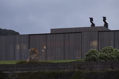 a large building with two chimneys on top of it's roof and grass in the foreground