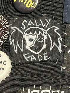 several badges and stickers are on the back of a jacket that has been sewn