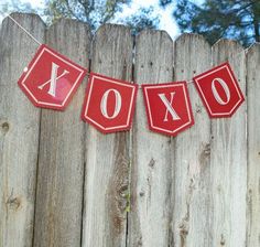 a red banner that says xoxo hanging on a fence