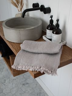 a bathroom sink with two bottles and a towel on the counter