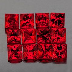 red glass cubes sitting on top of a table next to each other in rows