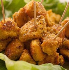 chicken skewers with toothpicks on top of lettuce leaves