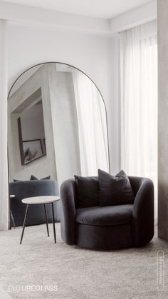 a living room with a round mirror on the wall next to a couch and table