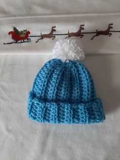 a blue knitted hat sitting on top of a bed